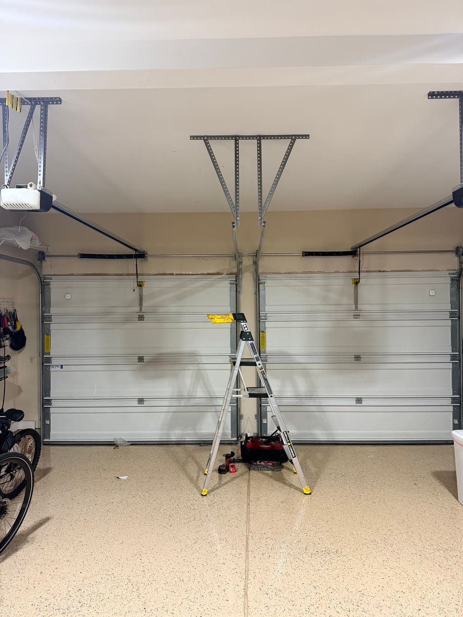 Double garage with both doors closed after a spring and roller replacement, ladder still in place