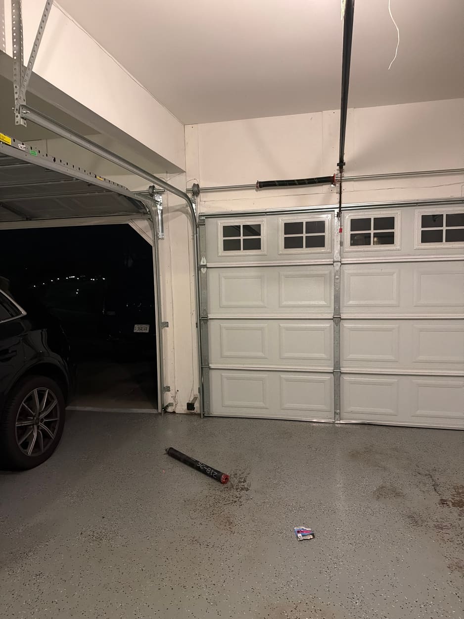 Garage at night after a spring replacement, the old spring lying on the floor