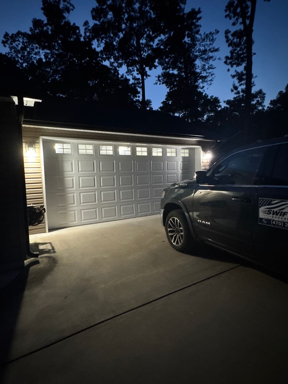 The same garage door closed and level that night after Swift Lift put it back on its track, company truck in the driveway