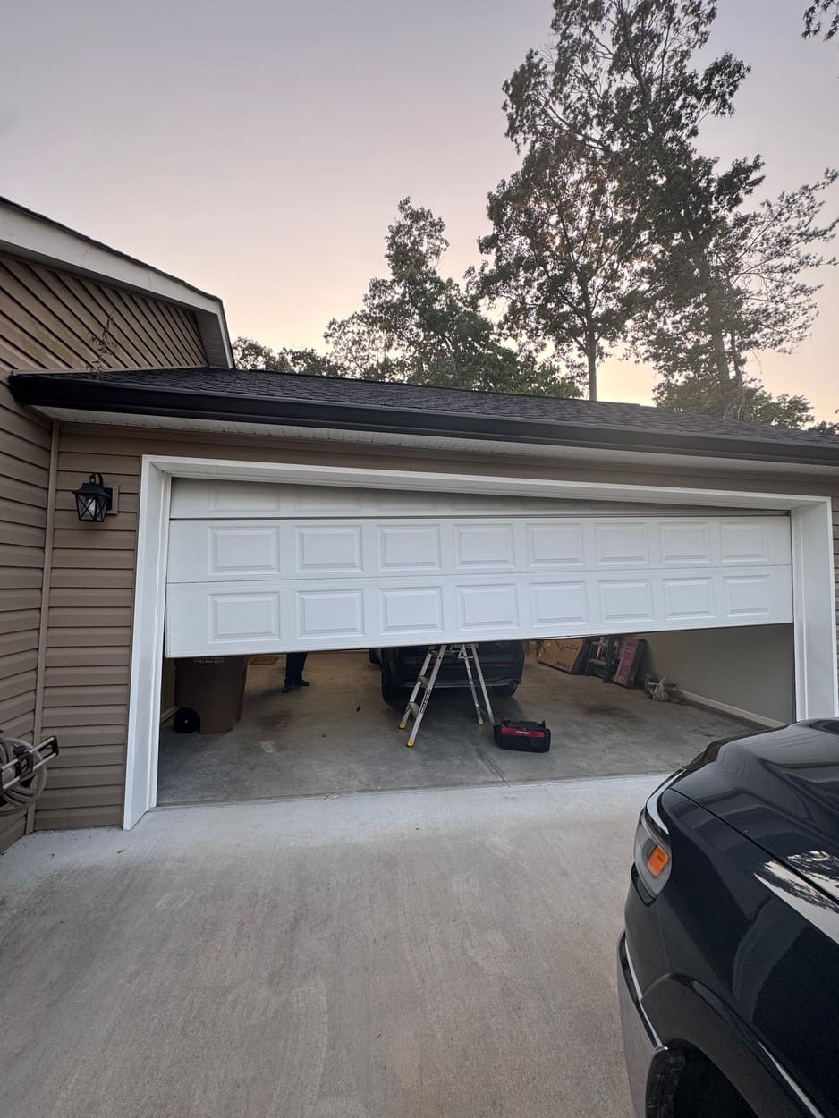 Garage door hanging crooked and half open after coming off its track, before the repair