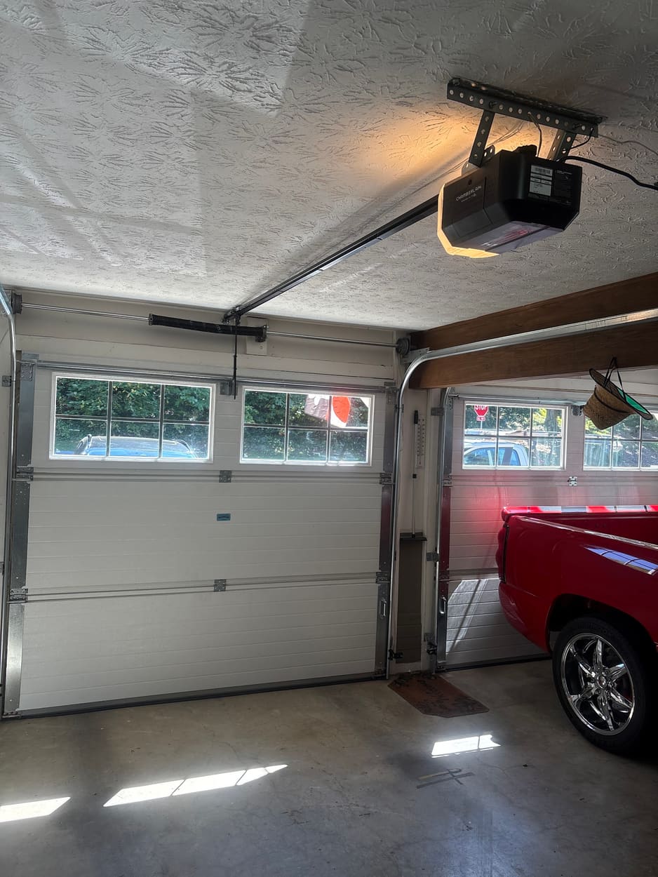 Garage door opener above a garage door with a row of windows