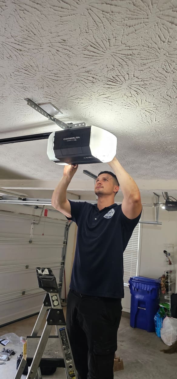 Swift Lift technician securing a new garage door opener motor unit overhead
