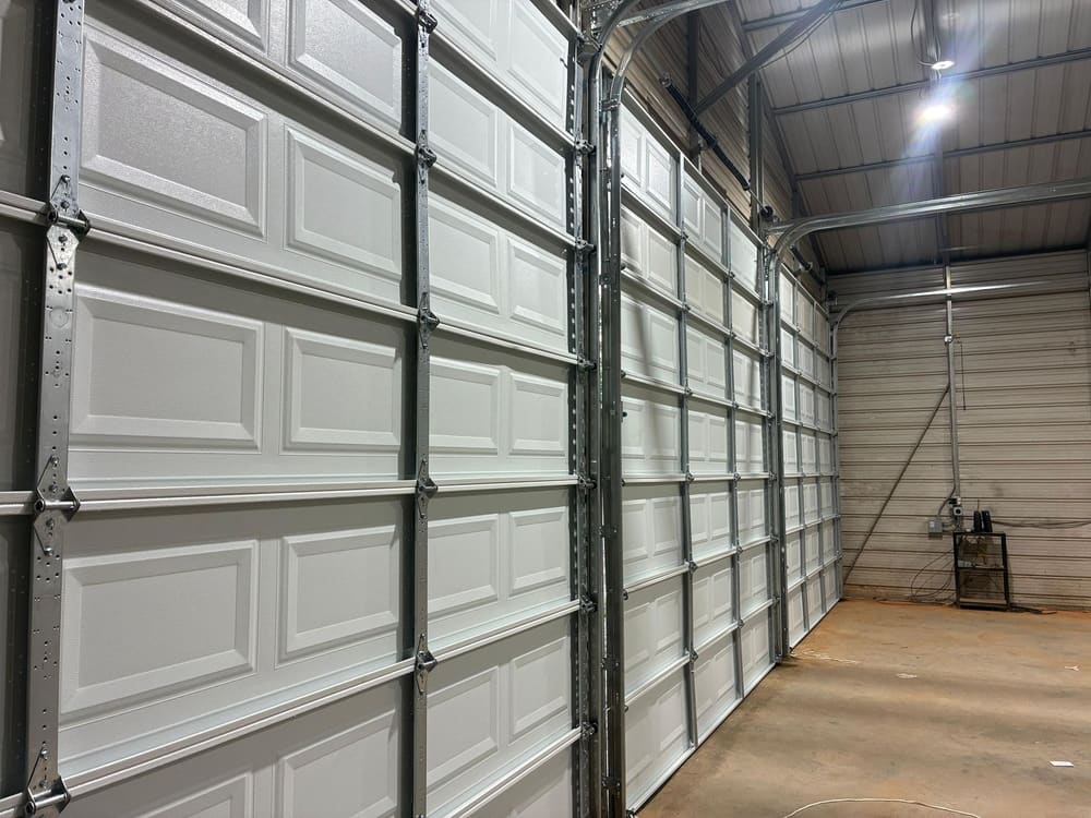 Tall sectional steel garage doors inside a metal building