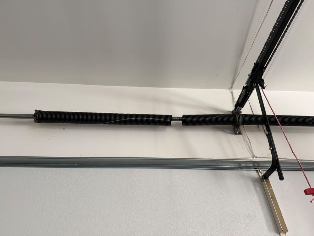 Pair of torsion springs with a center bearing bracket above a garage door