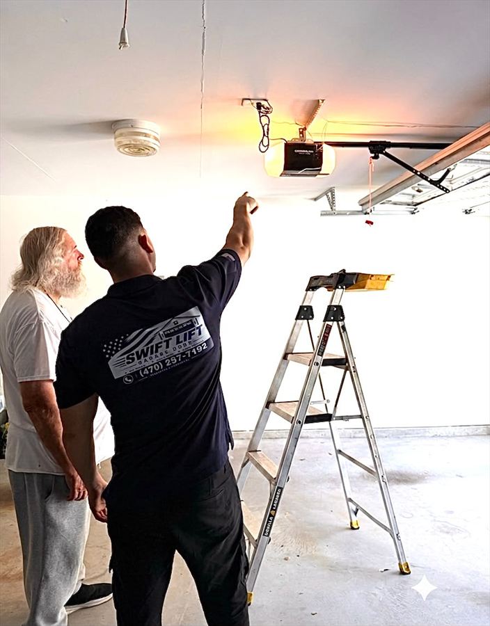 SwiftLift technician pointing out the fault on a garage door opener and explaining the repair to the homeowner before starting work